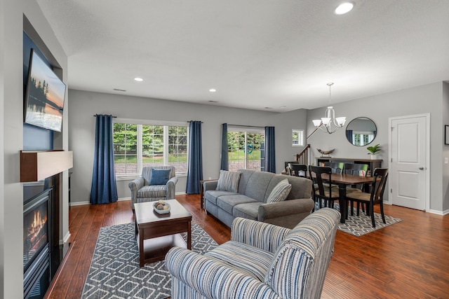 12266 Midway Cir NE, Blaine, MN 55449 - living area featuring a chandelier, a glass covered fireplace, hardwood / wood-style flooring, recessed lighting, and baseboards