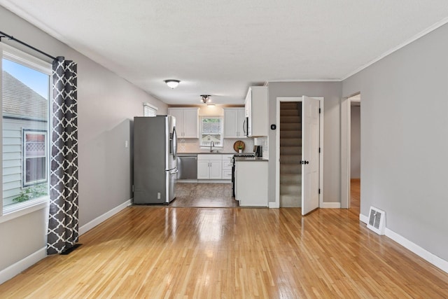 426 14th Ave N, Hopkins, MN 55343 - unfurnished living room with light wood-style flooring and baseboards