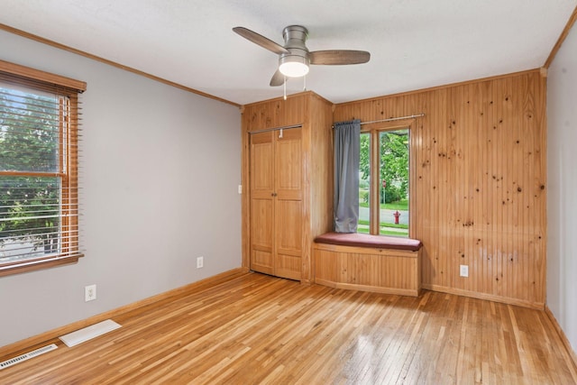 426 14th Ave N, Hopkins, MN 55343 - empty room featuring hardwood / wood-style flooring, a ceiling fan, crown molding, baseboards, and wooden walls