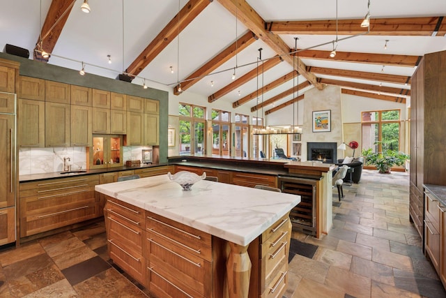 20545 Linden Rd, Deephaven, MN 55331 - kitchen with wine cooler, stone tile flooring, a kitchen island, beam ceiling, and open floor plan