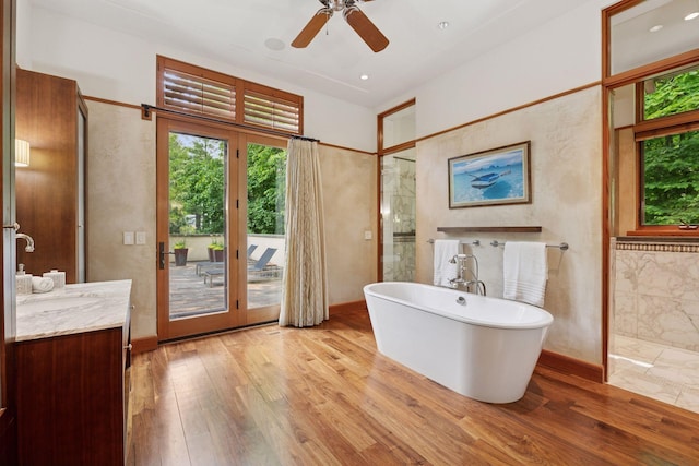 20545 Linden Rd, Deephaven, MN 55331 - bathroom featuring a soaking tub, vanity, wood finished floors, ceiling fan, and a shower
