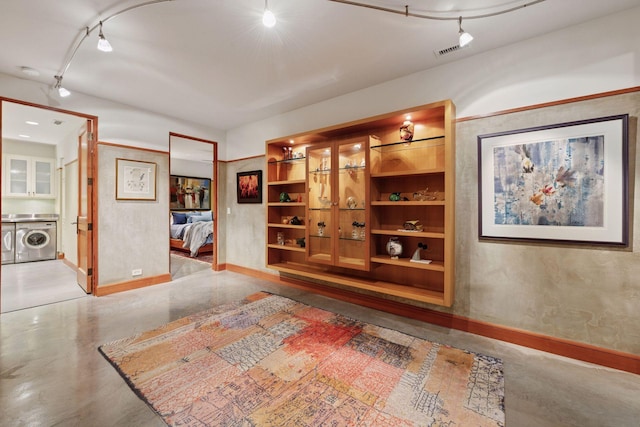20545 Linden Rd, Deephaven, MN 55331 - hallway featuring rail lighting, baseboards, concrete flooring, and washing machine and clothes dryer