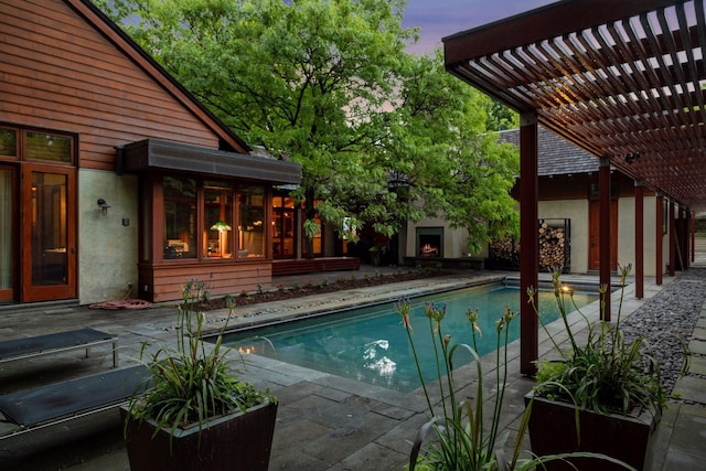 20545 Linden Rd, Deephaven, MN 55331 - pool at dusk with a pergola, a patio, a warm lit fireplace, and an outdoor pool