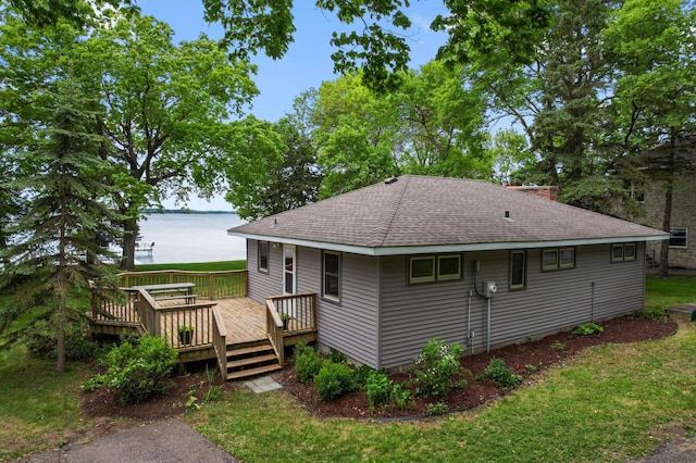 10001 Jeske Ave NW, Corinna Twp, MN 55302 - back of house featuring a shingled roof, a deck with water view, a chimney, and a yard