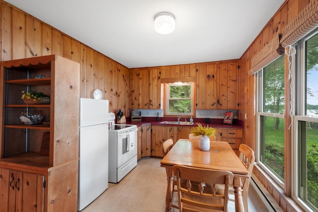 10001 Jeske Ave NW, Corinna Twp, MN 55302 - kitchen featuring white appliances, a sink, wooden walls, plenty of natural light, and dark countertops