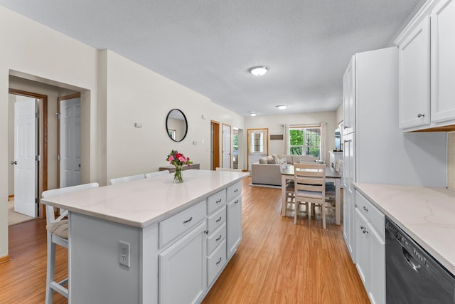 2737 Faulkner Dr, Chaska, MN 55318 - kitchen with dishwashing machine, a breakfast bar, open floor plan, and light wood finished floors