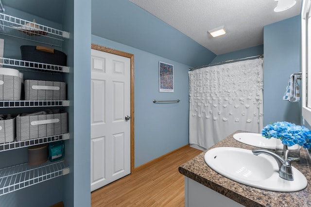 2737 Faulkner Dr, Chaska, MN 55318 - full bathroom featuring wood finished floors, lofted ceiling, vanity, and a textured ceiling