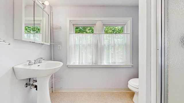 bathroom with baseboards, speckle patterned floor, and toilet