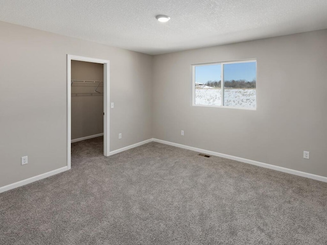 7463 147th Ln NW, Ramsey, MN 55303 - unfurnished bedroom featuring a spacious closet, carpet floors, baseboards, a textured ceiling, and a closet