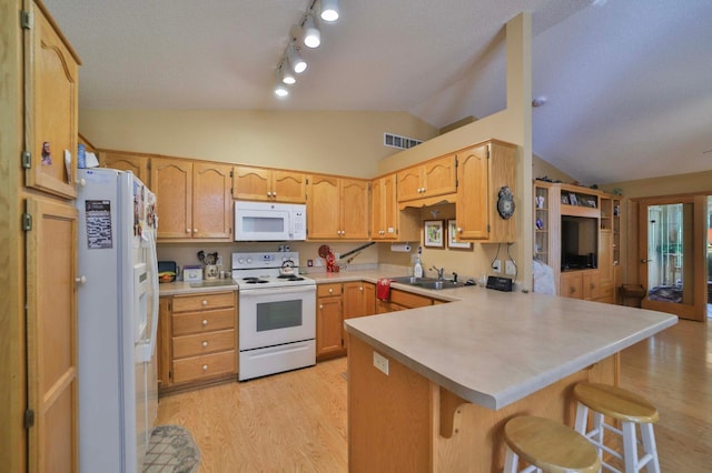 2506 Woodridge Ln, Brainerd, MN 56401 - kitchen with white appliances, vaulted ceiling, a peninsula, light wood-type flooring, and a sink