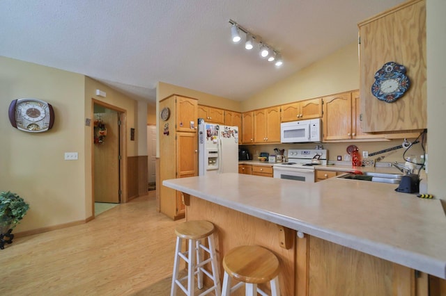 2506 Woodridge Ln, Brainerd, MN 56401 - kitchen with white appliances, a peninsula, light countertops, a sink, and vaulted ceiling