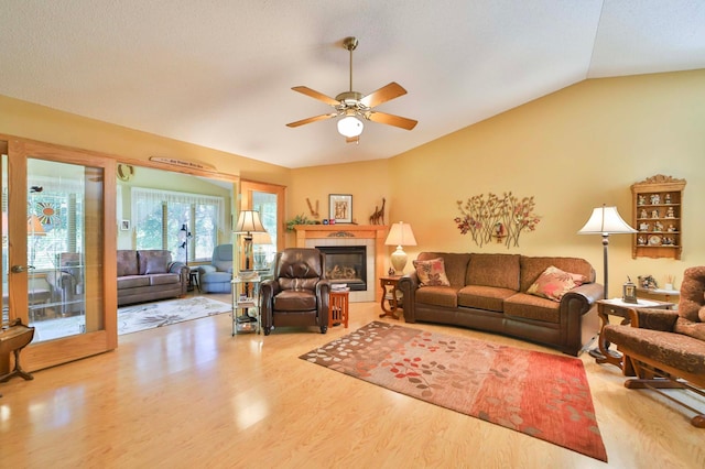 2506 Woodridge Ln, Brainerd, MN 56401 - living area featuring wood finished floors, vaulted ceiling, a ceiling fan, and a tile fireplace
