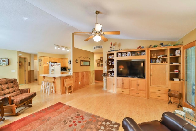 2506 Woodridge Ln, Brainerd, MN 56401 - living area with light wood finished floors, ceiling fan, vaulted ceiling, and a wainscoted wall
