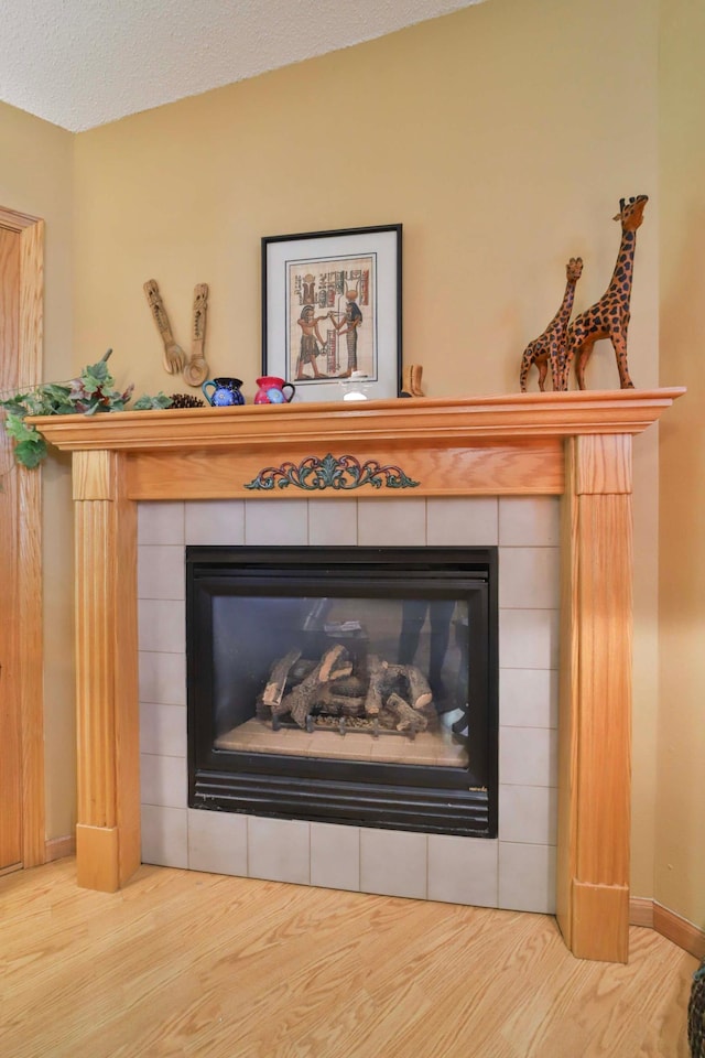 2506 Woodridge Ln, Brainerd, MN 56401 - detailed view of a tile fireplace, wood finished floors, a textured ceiling, and baseboards