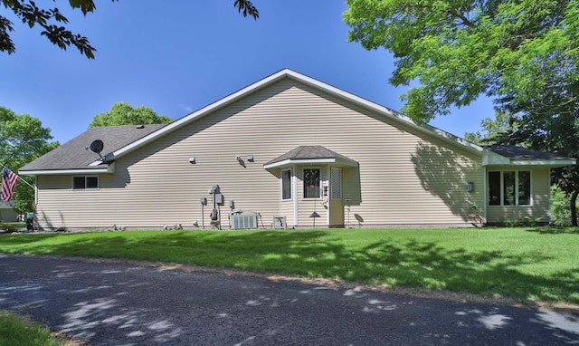 2506 Woodridge Ln, Brainerd, MN 56401 - back of property featuring a lawn, a shingled roof, and central AC