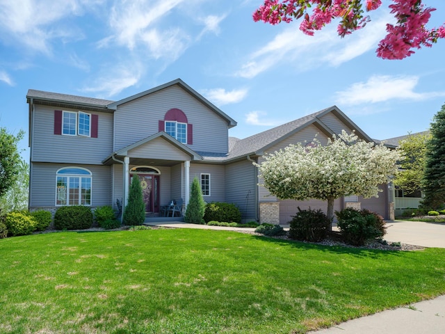 view of front of house featuring driveway, a front yard, a porch, and a garage