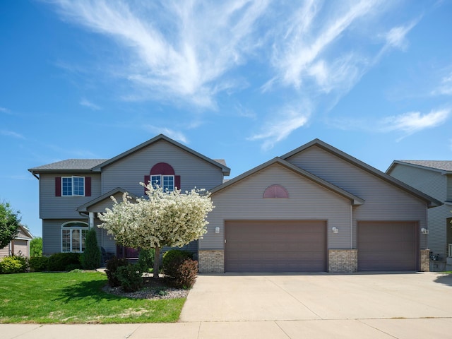 view of front of property with a garage, driveway, a front yard, and brick siding