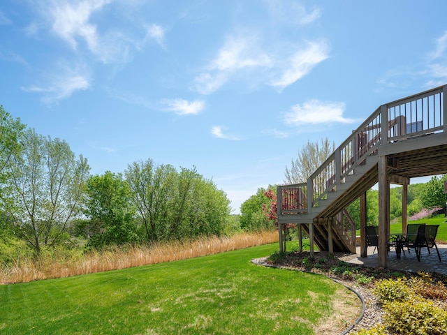 view of grassy yard with stairs, a patio, and a wooden deck