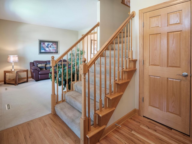 staircase with wood finished floors and baseboards