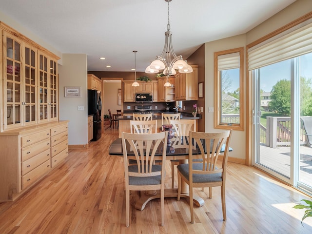 dining space featuring baseboards, light wood finished floors, recessed lighting, and a chandelier