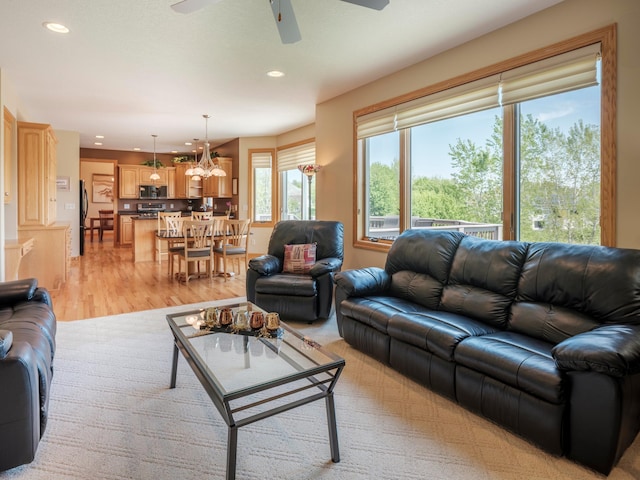 living area with recessed lighting, ceiling fan, light wood-style floors, and a chandelier