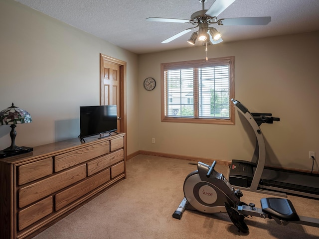 workout room with light carpet, ceiling fan, a textured ceiling, and baseboards