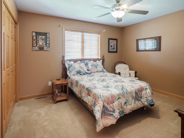 bedroom featuring light carpet, baseboards, and a closet