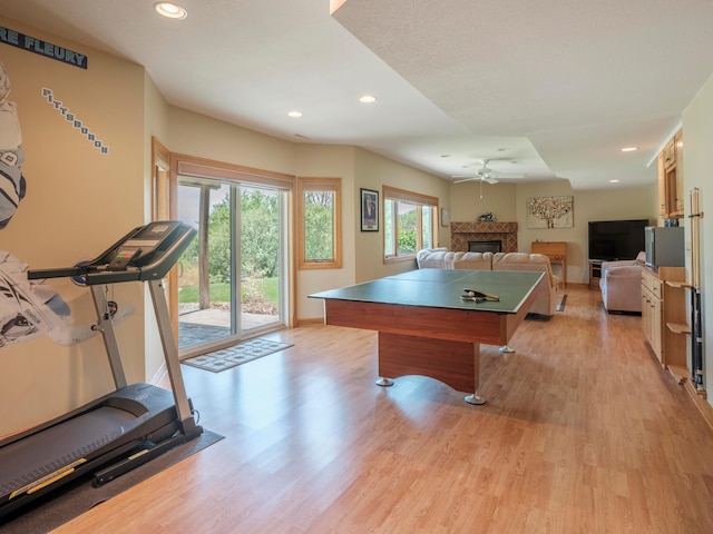recreation room with ceiling fan, light wood-style floors, recessed lighting, a fireplace, and baseboards