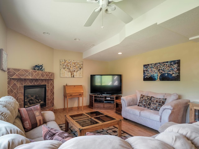 living area with wood finished floors, recessed lighting, ceiling fan, a tile fireplace, and baseboards