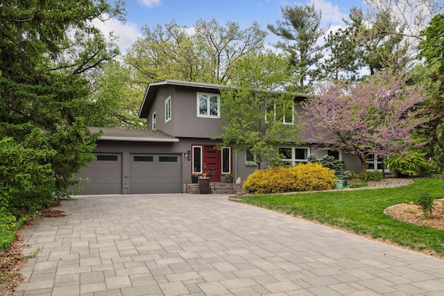 154 Woodland Dr, Burnsville, MN 55337 - view of front of house with decorative driveway, an attached garage, and a front lawn