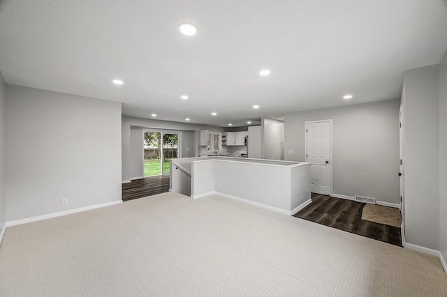 3213 63rd Ave N, Brooklyn Center, MN 55429 - kitchen featuring recessed lighting, baseboards, dark colored carpet, a kitchen island, and light countertops
