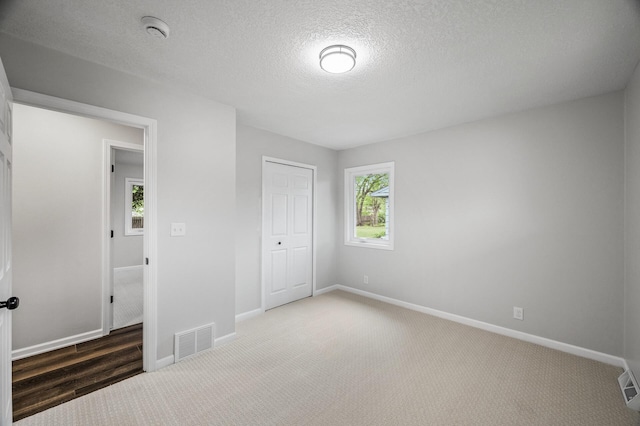 3213 63rd Ave N, Brooklyn Center, MN 55429 - unfurnished bedroom with carpet flooring, baseboards, a textured ceiling, and a closet