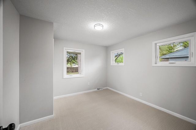 3213 63rd Ave N, Brooklyn Center, MN 55429 - unfurnished room featuring light colored carpet, baseboards, and a textured ceiling