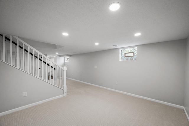3213 63rd Ave N, Brooklyn Center, MN 55429 - below grade area with light carpet, recessed lighting, baseboards, stairway, and a textured ceiling