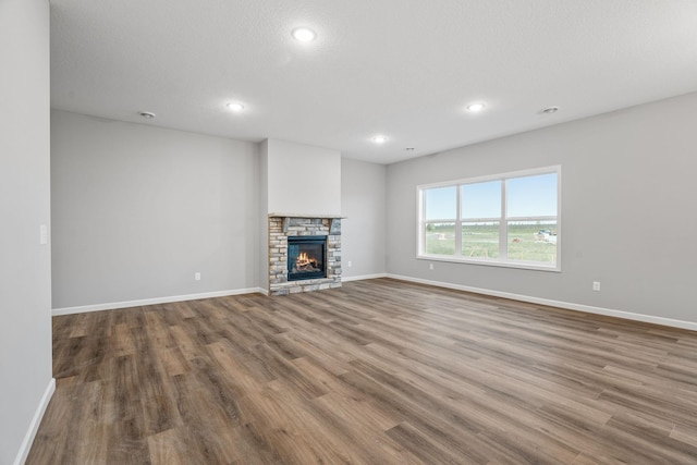 14617 Quintana St NW, Ramsey, MN 55303 - unfurnished living room with wood finished floors, baseboards, recessed lighting, and a fireplace