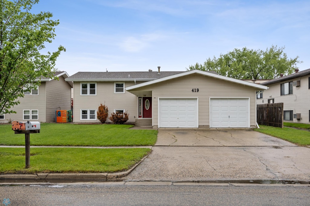 419 5th St E, West Fargo, ND 58078 - view of front of home featuring driveway, a garage, and a front yard