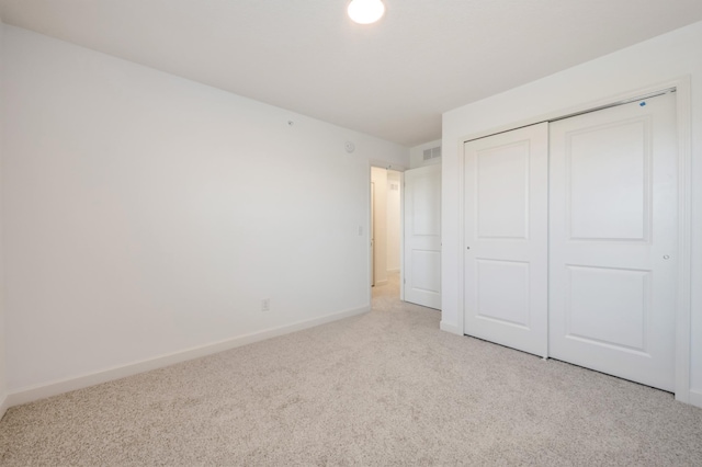 unfurnished bedroom with carpet flooring, a closet, and baseboards