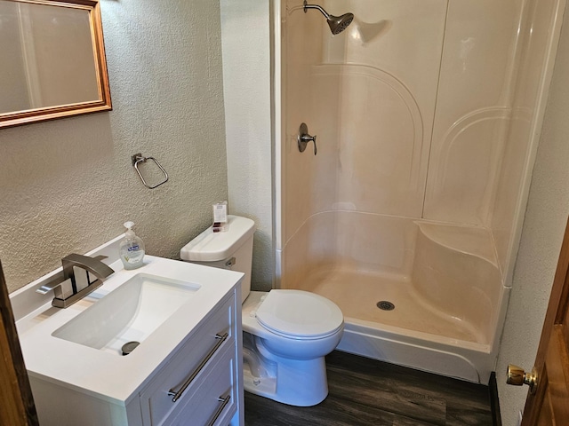 2729 King Ave, Slayton, MN 56172 - bathroom with a textured wall, wood finished floors, a walk in shower, toilet, and vanity