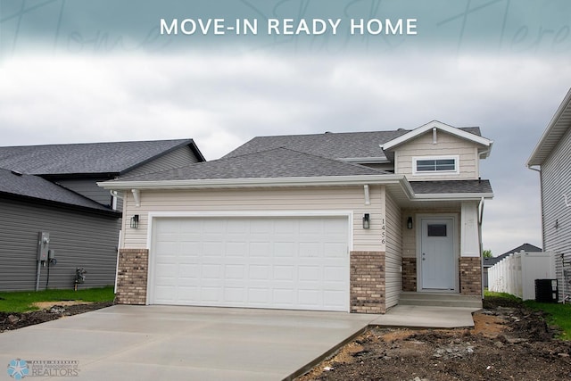 1456 69th Ave S, Fargo, ND 58104 - craftsman-style house with brick siding, concrete driveway, an attached garage, and cooling unit