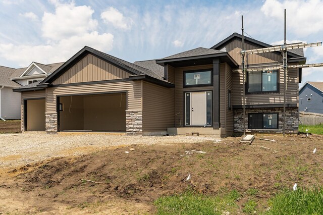 1806 Brandt Dr NE, Byron, MN 55920 - view of front of house with stone siding, an attached garage, driveway, and board and batten siding