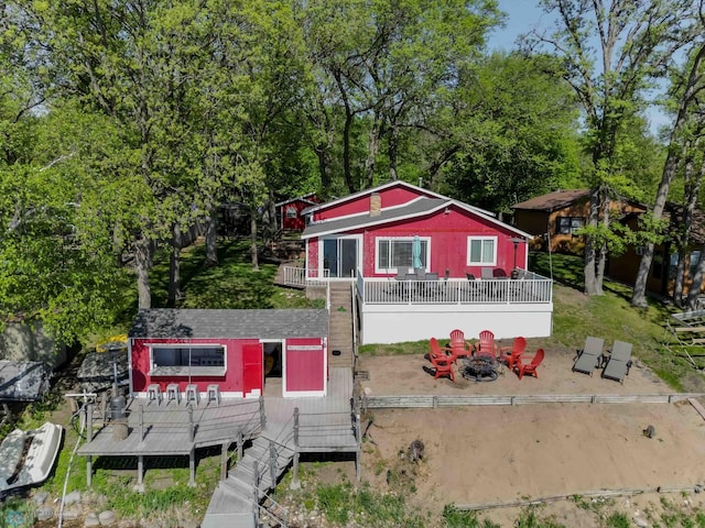 1143 Long Beach Dr, Detroit Lakes, MN 56501 - back of property with a fire pit, a wooden deck, and stairs