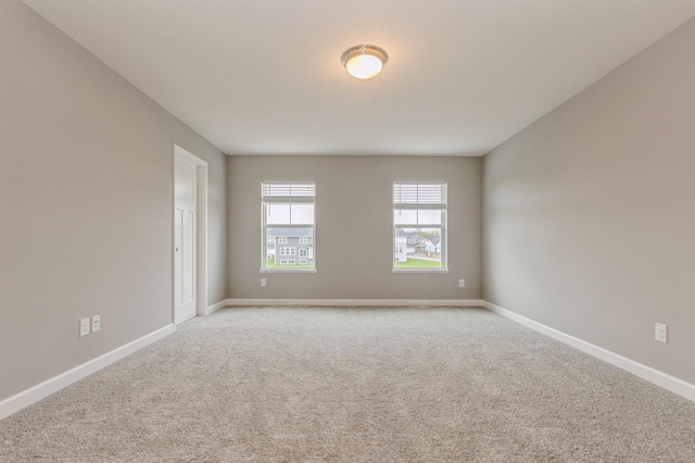 empty room with light carpet and baseboards