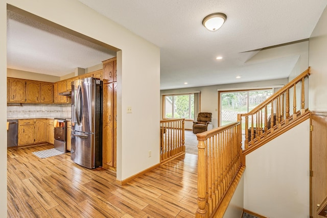 121 Yorkton Rdg, Little Canada, MN 55117 - kitchen with appliances with stainless steel finishes, light wood-style flooring, light countertops, backsplash, and brown cabinets