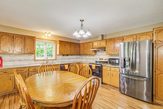 121 Yorkton Rdg, Little Canada, MN 55117 - kitchen featuring stainless steel appliances, brown cabinets, a chandelier, light countertops, and light wood-style floors