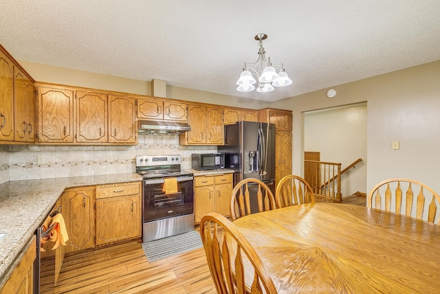121 Yorkton Rdg, Little Canada, MN 55117 - kitchen featuring appliances with stainless steel finishes, under cabinet range hood, a chandelier, light wood-style floors, and backsplash