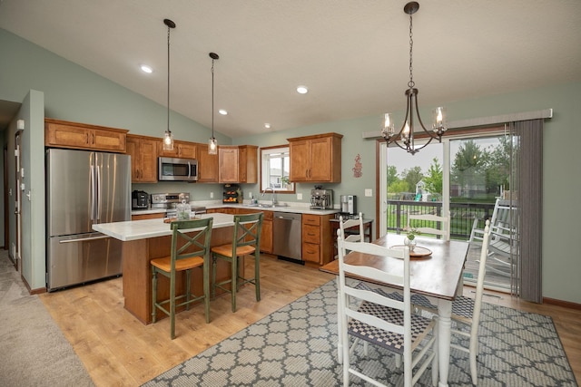 802 10th St NE, Kasson, MN 55944 - kitchen featuring stainless steel appliances, a sink, a center island, light countertops, and brown cabinetry