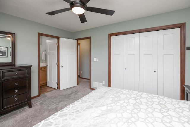 802 10th St NE, Kasson, MN 55944 - carpeted bedroom featuring a closet, baseboards, a ceiling fan, and connected bathroom
