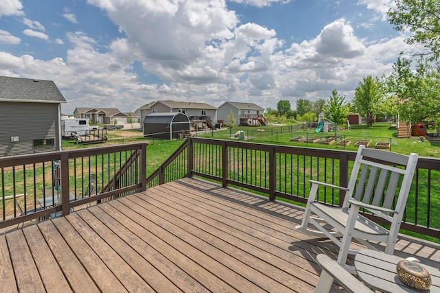 802 10th St NE, Kasson, MN 55944 - deck featuring a playground, a storage unit, an outdoor structure, and a residential view