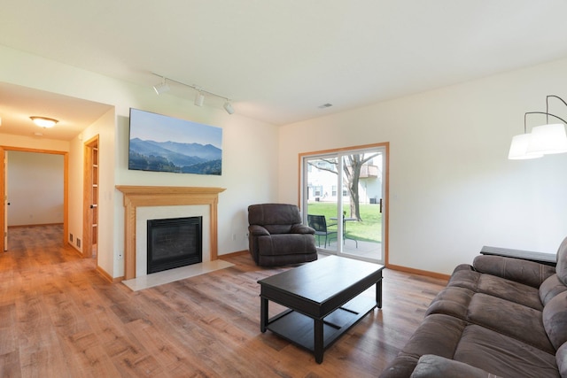 6509 154th St W, Apple Valley, MN 55124 - living room with rail lighting, wood finished floors, a fireplace with flush hearth, and baseboards
