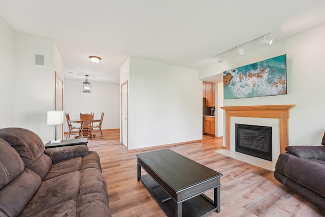 6509 154th St W, Apple Valley, MN 55124 - living area with rail lighting, light wood-type flooring, a fireplace with flush hearth, and baseboards